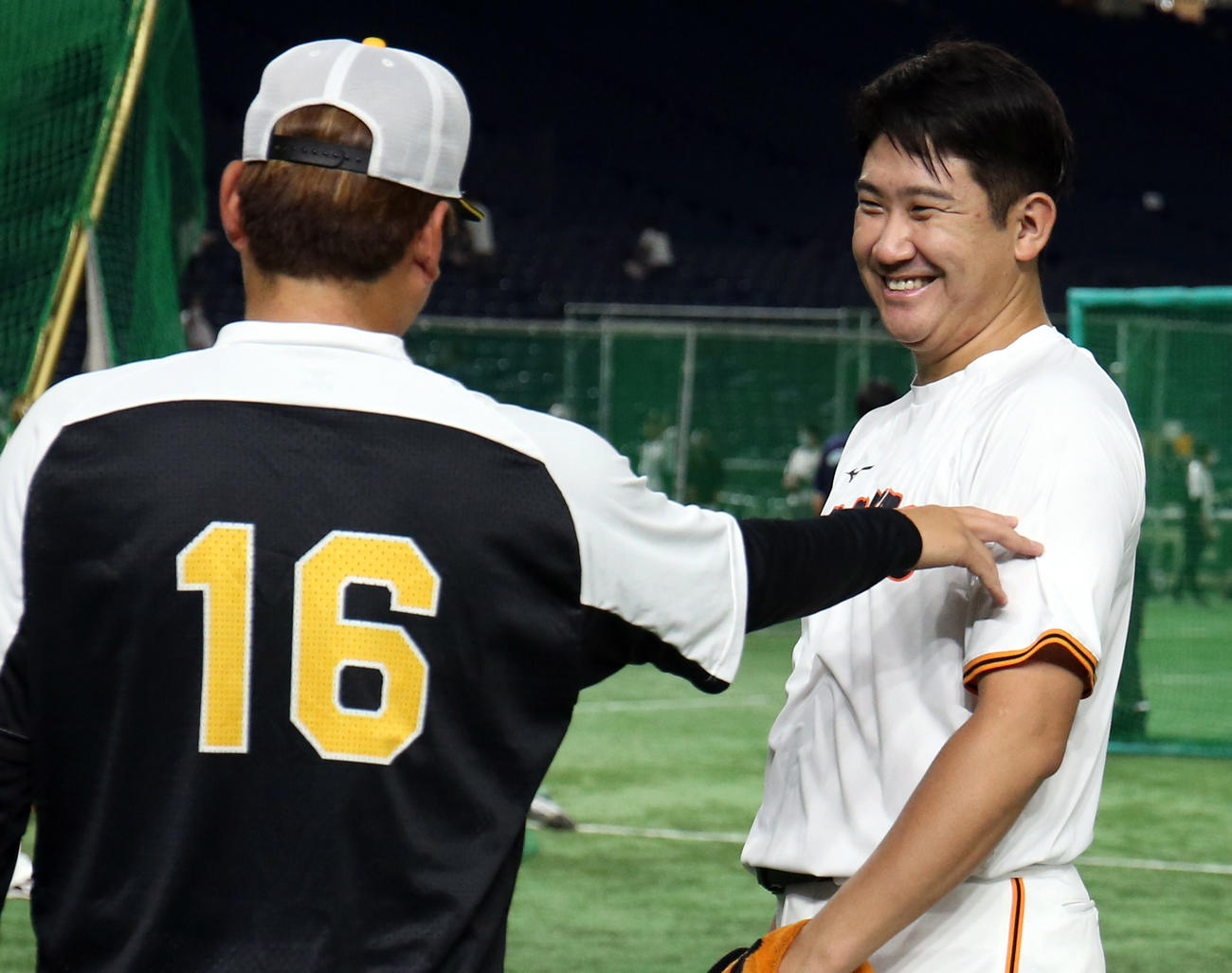 巨人対阪神　試合前、西勇（手前）と談笑する菅野（撮影・狩俣裕三）
