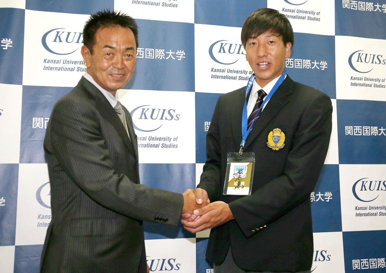 巨人ドラフト1位の関西国際大・翁田（右）は指名あいさつに訪れた水野スカウト部長とがっちり握手を交わす（撮影・上山淳一）