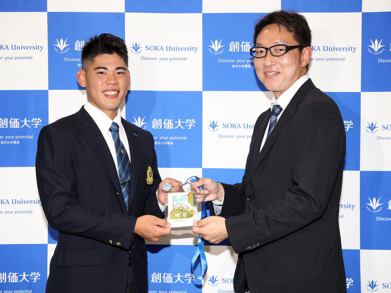 吉野スカウト（右）から矢野監督サイン入りドラフト会場入場証を手渡される鈴木（撮影・加藤哉）