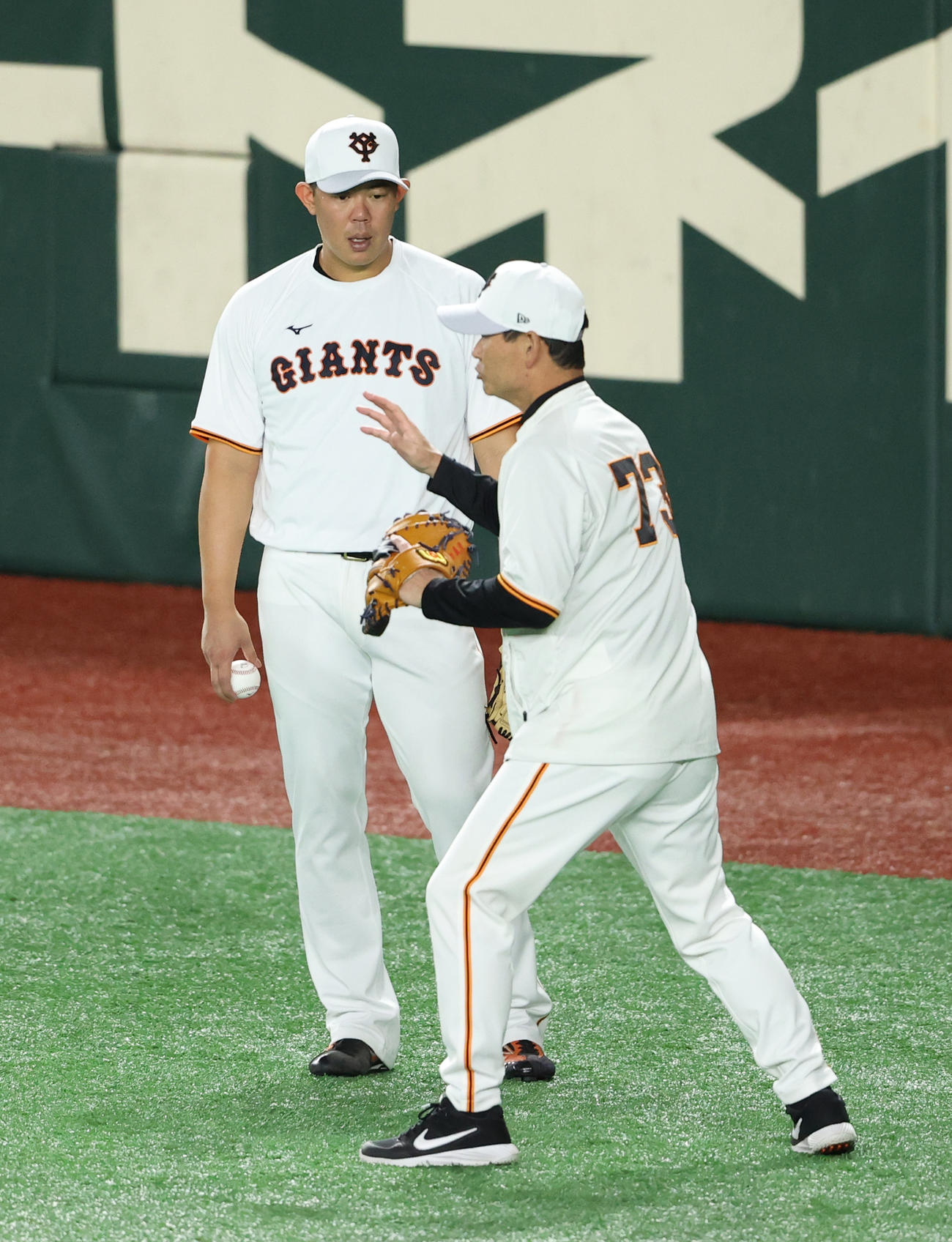 巨人対阪神　試合前、巨人桑田コーチ（手前）の指導を受ける山口（2021年10月13日撮影）
