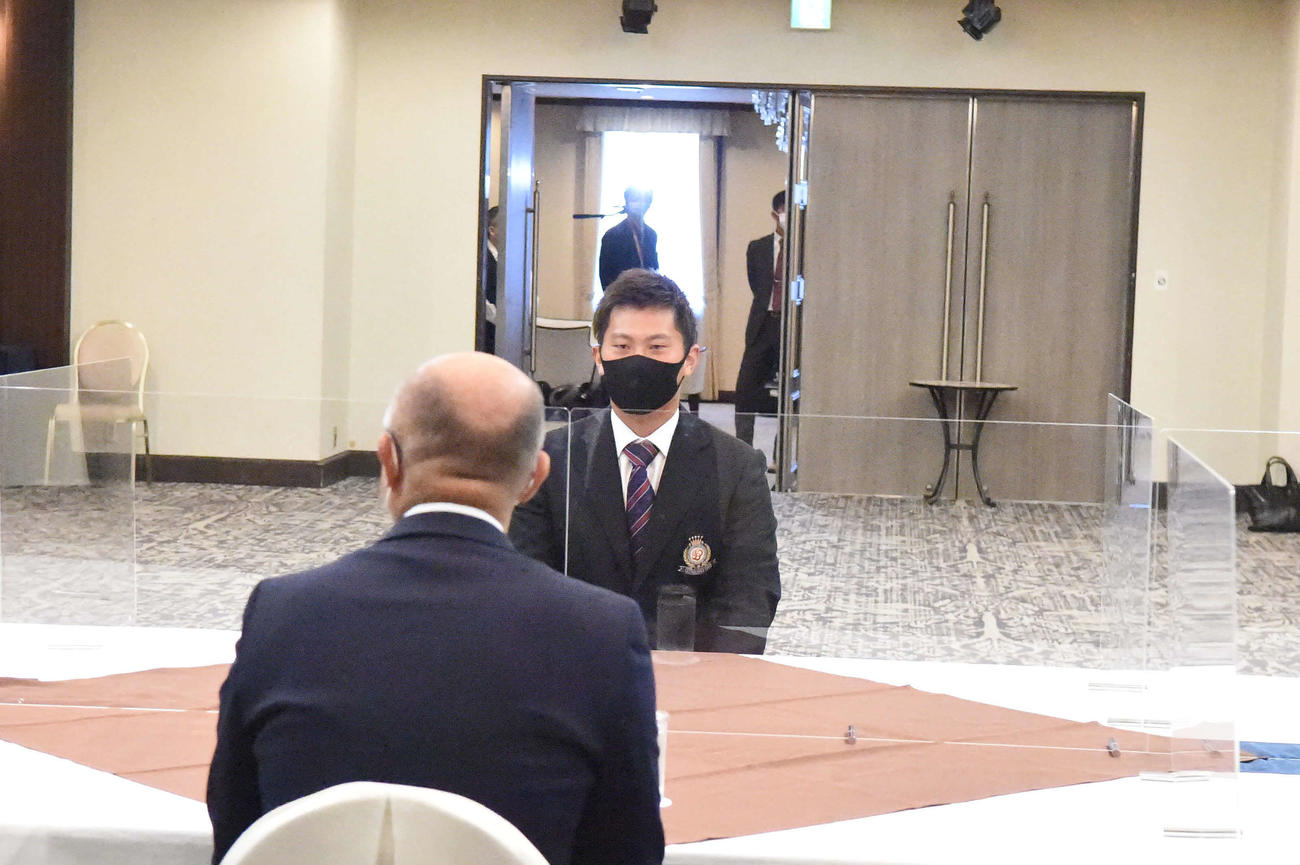 新潟市内のホテルでドラフト指名あいさつに応じる新潟医療福祉大・桐敷拓馬投手（奥）、手前は阪神畑山統括スカウト