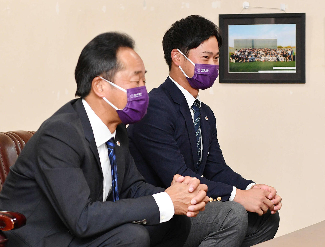 指名あいさつを受け笑顔を見せるヤクルトドラフト2位の明大・丸山（奥）。手前は明大・田中監督（撮影・滝沢徹郎）