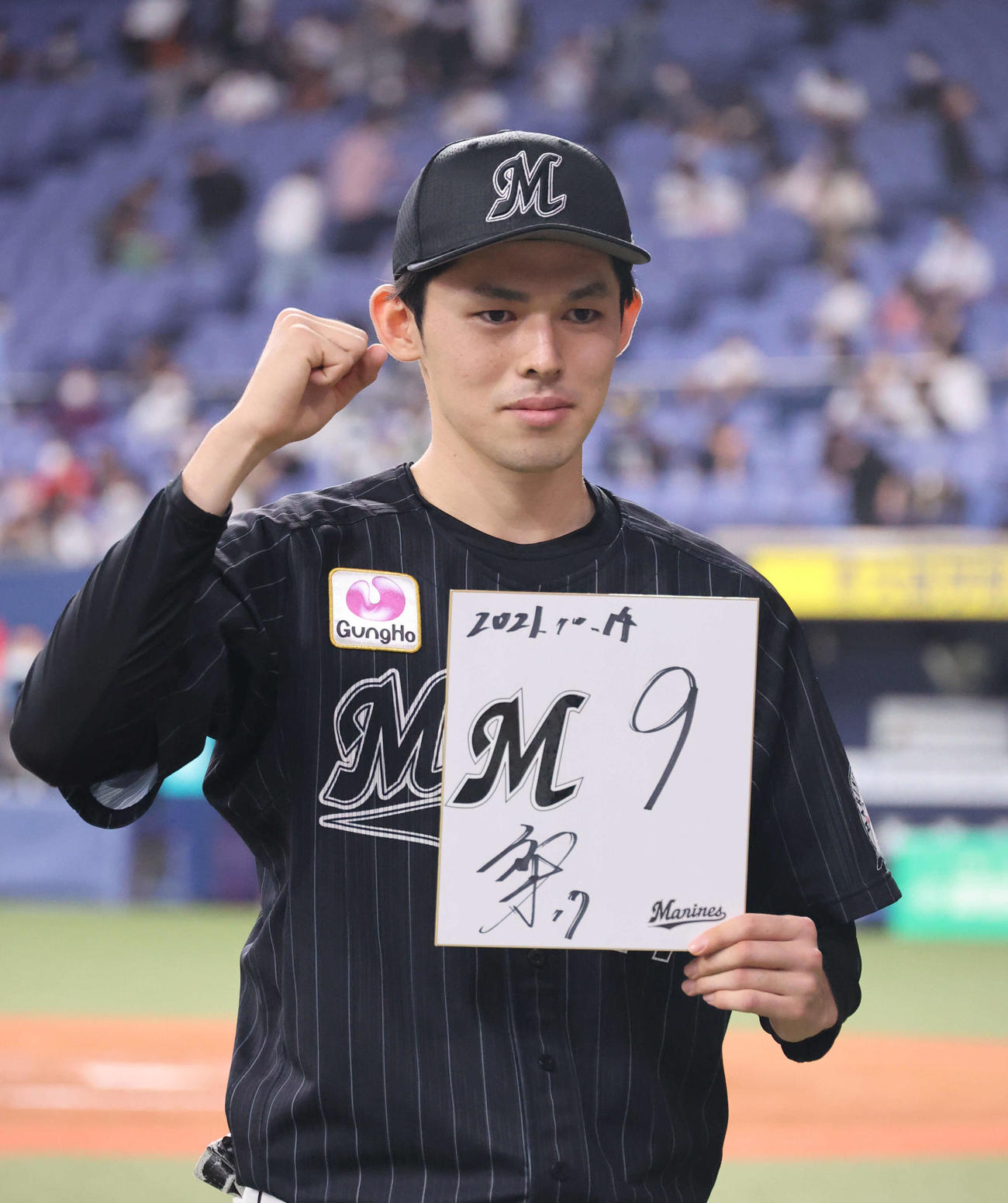 オリックス対ロッテ　M9の色紙を手にファンにガッツポーズのロッテ佐々木朗（撮影・渦原淳）