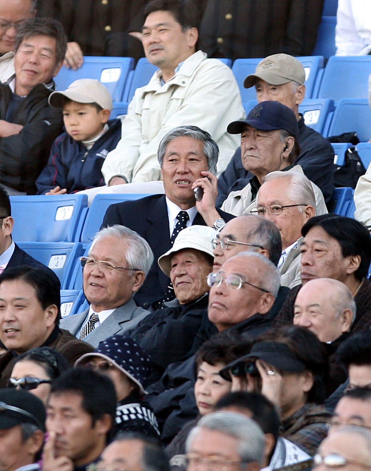 08年10月、携帯電話で話しながら、試合をネット裏から観戦する当時阪神東日本統括スカウトの菊地敏幸氏（中央）