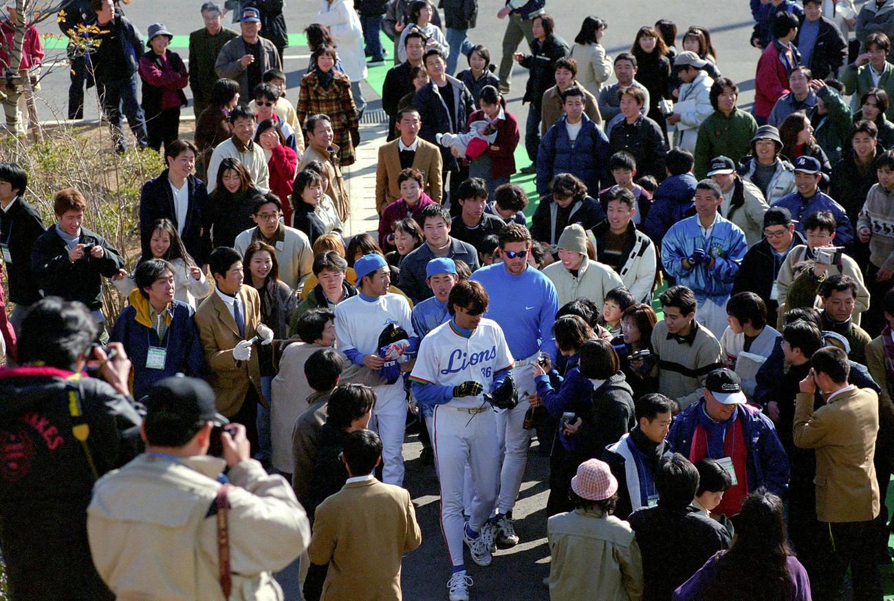 99年2月、多くのファンが追いかけられデニー友利（手前）らチームメートにガードされながら移動する松坂
