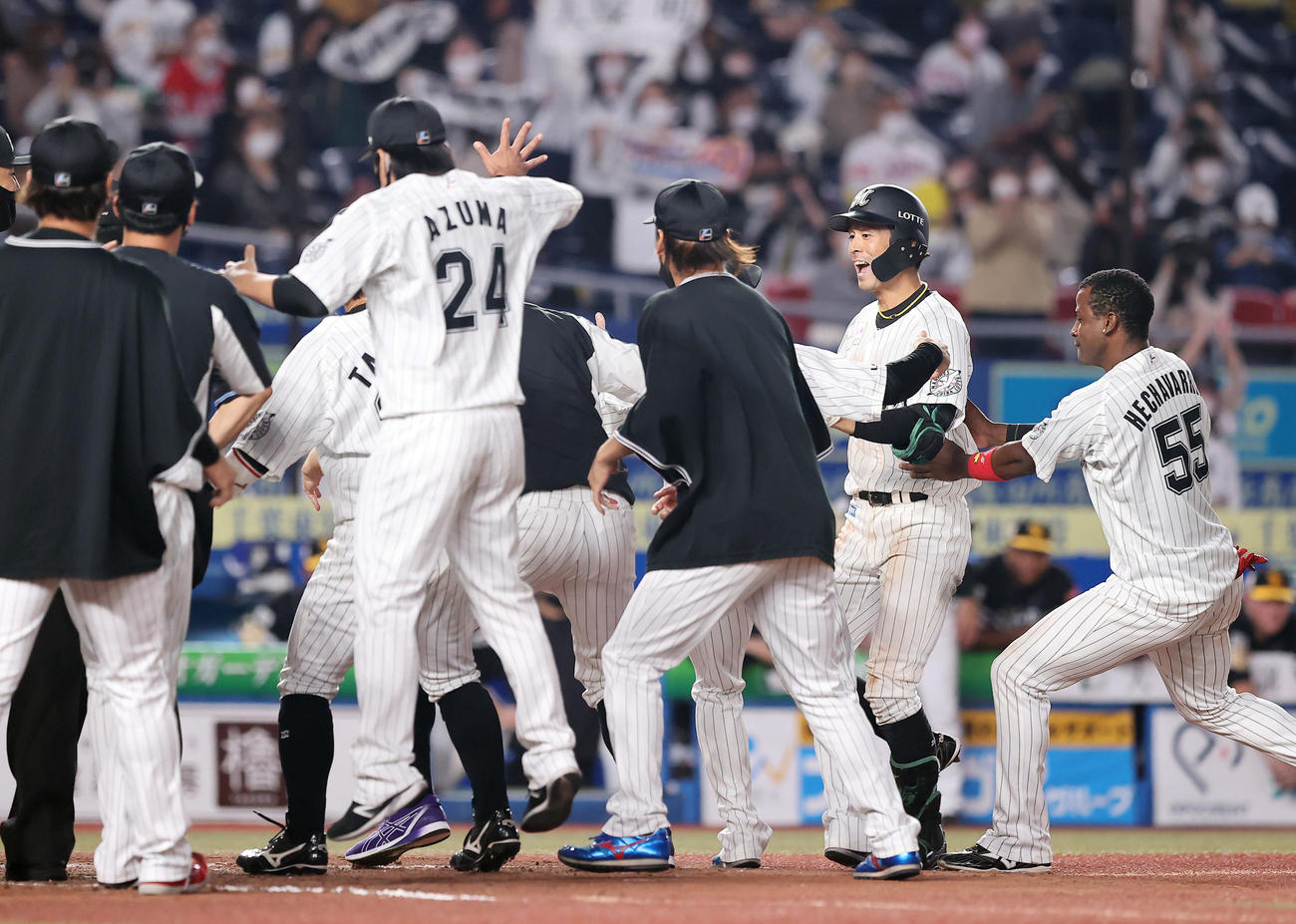 ロッテ対ソフトバンク　9回裏ロッテ2死一塁、サヨナラ2点本塁打を放ちナインの出迎えを受ける岡（右から2人目）（撮影・垰建太）