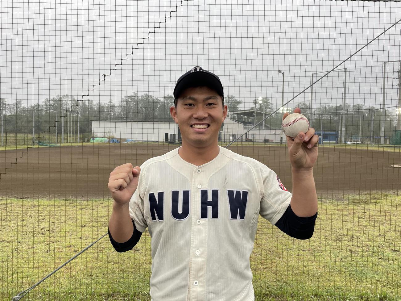 平成国際大戦で完全試合を達成した新潟医療福祉大・桐敷拓馬は、記念球を手に笑顔を見せる（新潟医療福祉大硬式野球部提供）