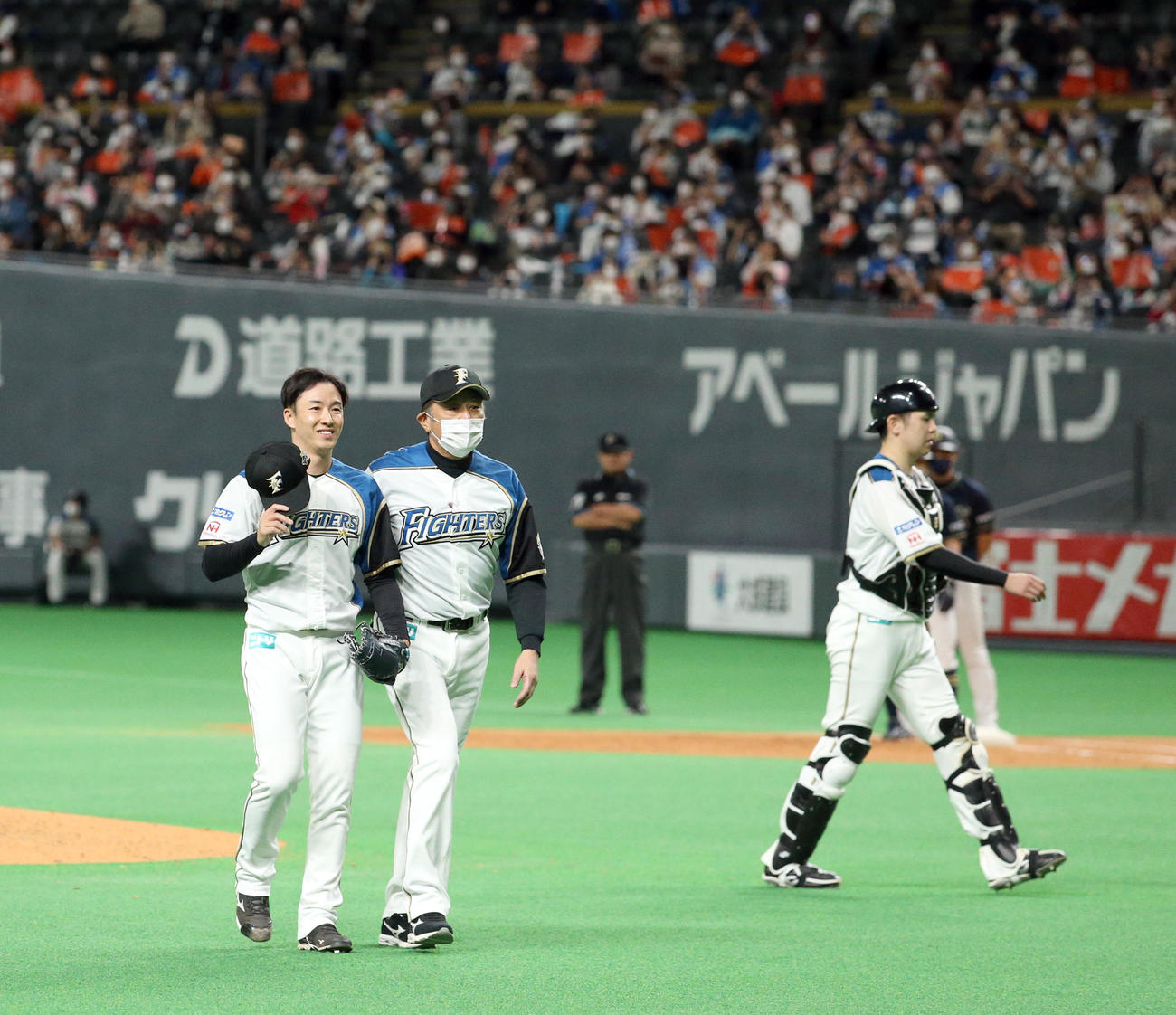 登板を終え日本ハム荒木投手コーチと共にベンチに引き上げる斎藤（左）（撮影・佐藤翔太）