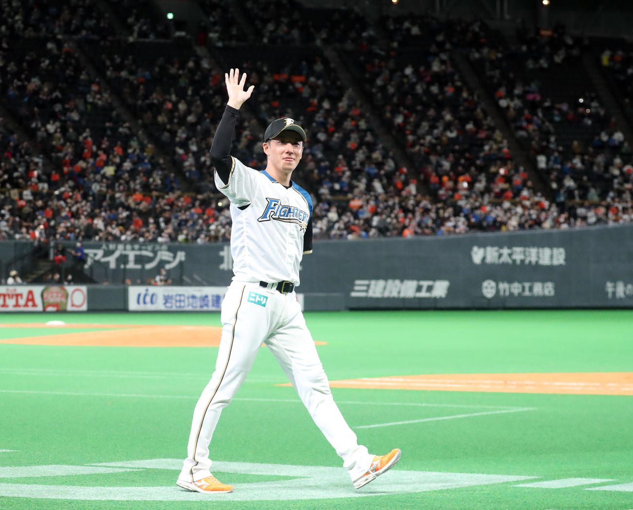 引退セレモニーでスタンド応援席のファンに笑顔で手をふりながらグラウンドを一周する日本ハム斎藤（撮影・佐藤翔太）