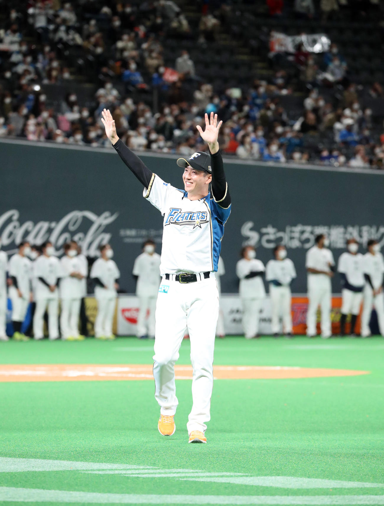 引退セレモニーでスタンド応援席のファンに笑顔で手をふりながらグラウンドを一周する日本ハム斎藤（撮影・佐藤翔太）