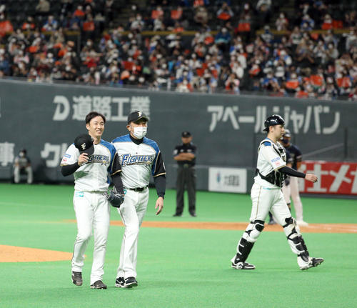 登板を終え日本ハム荒木投手コーチと共にベンチに引き上げる斎藤（左）（撮影・佐藤翔太）