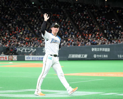 引退セレモニーでスタンド応援席のファンに笑顔で手をふりながらグラウンドを一周する日本ハム斎藤（撮影・佐藤翔太）