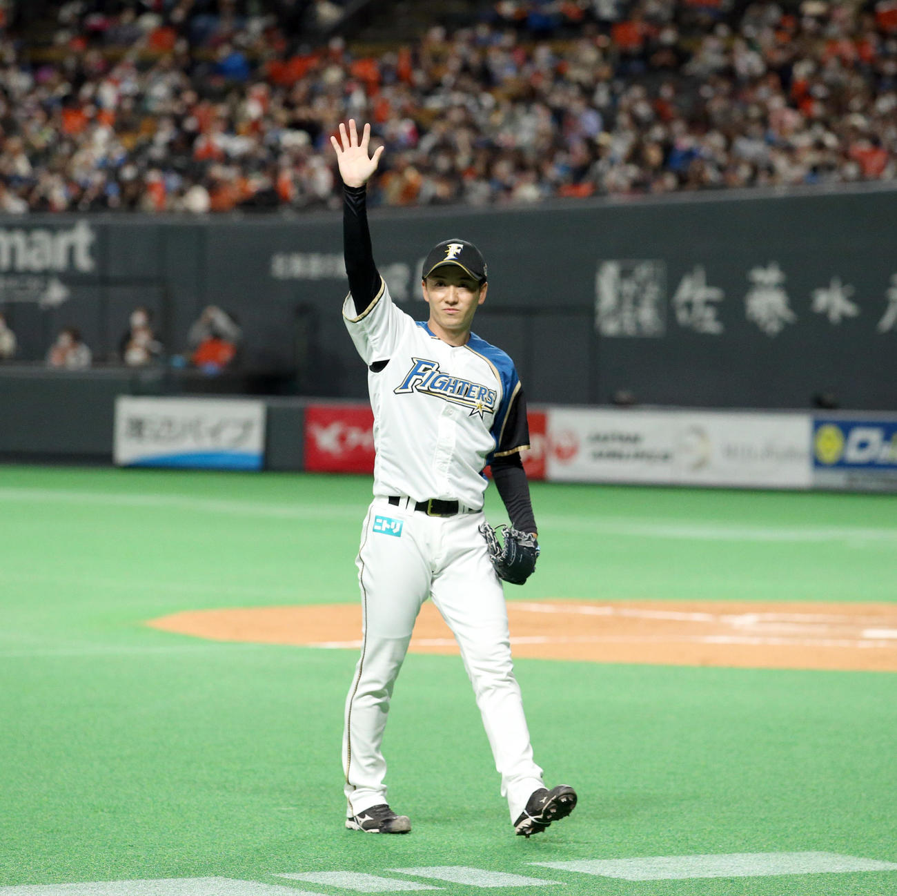 日本ハム対オリックス　最後の登板を終えスタンド応援席のファンに手を振りながらベンチに戻る日本ハム斎藤（撮影・佐藤翔太）