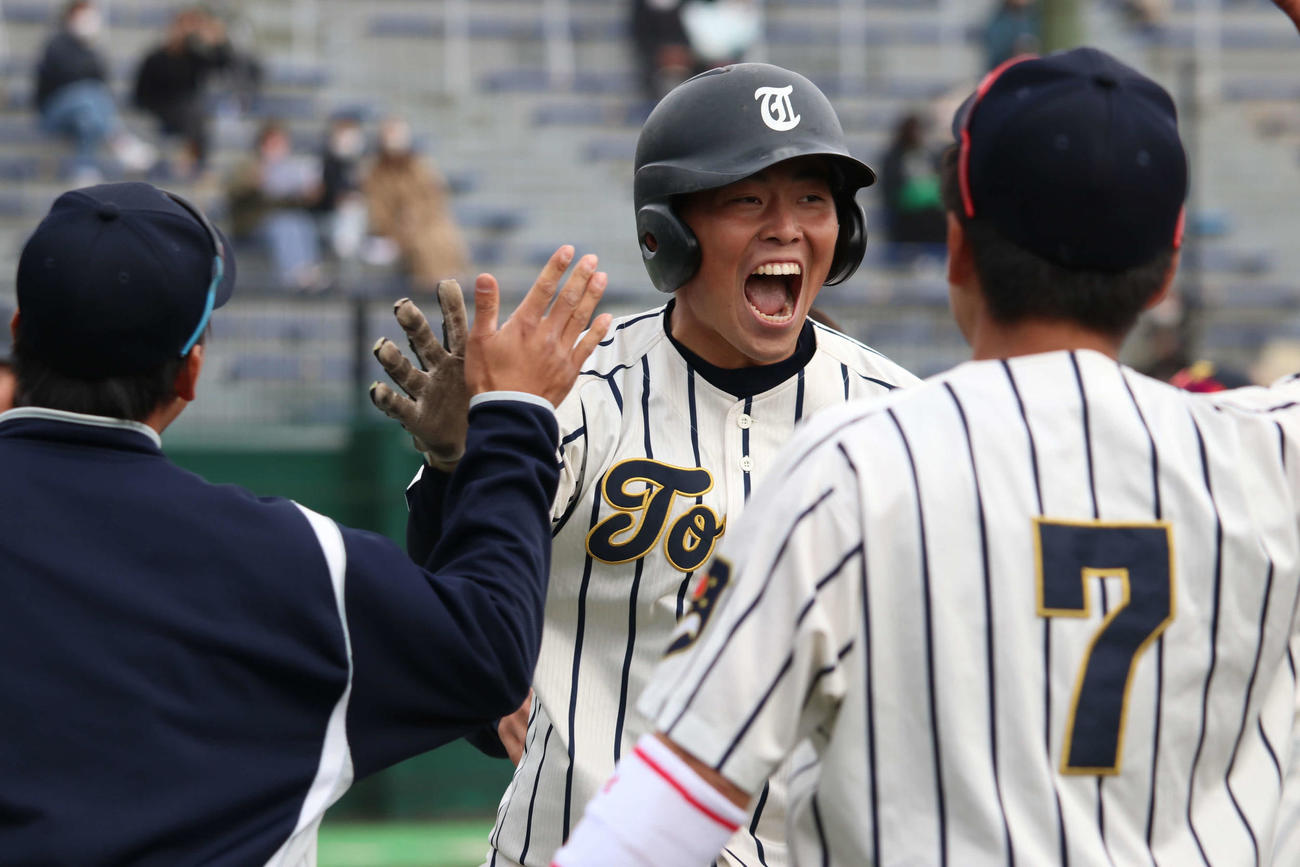 東海大北海道対東農大北海道　7回表東海大北海道1死一、二塁、中越えに同点3ランを放ち、チームメートとハイタッチする中野（撮影・山崎純一）