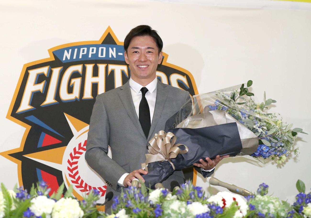 引退会見で花束を手に笑顔の斎藤（撮影・黒川智章）