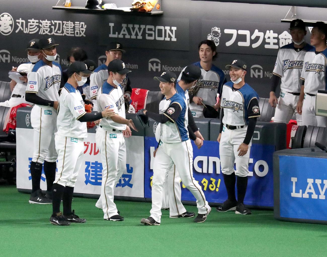 日本ハム対オリックス　7回表、ナインに送り出されマウンドに向かう斎藤（撮影・黒川智章）