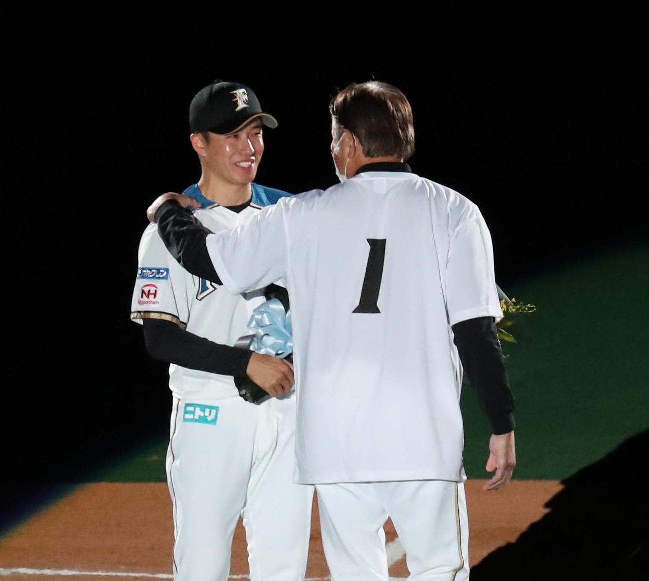 荒木投手コーチから花束を渡される斎藤（撮影・黒川智章）