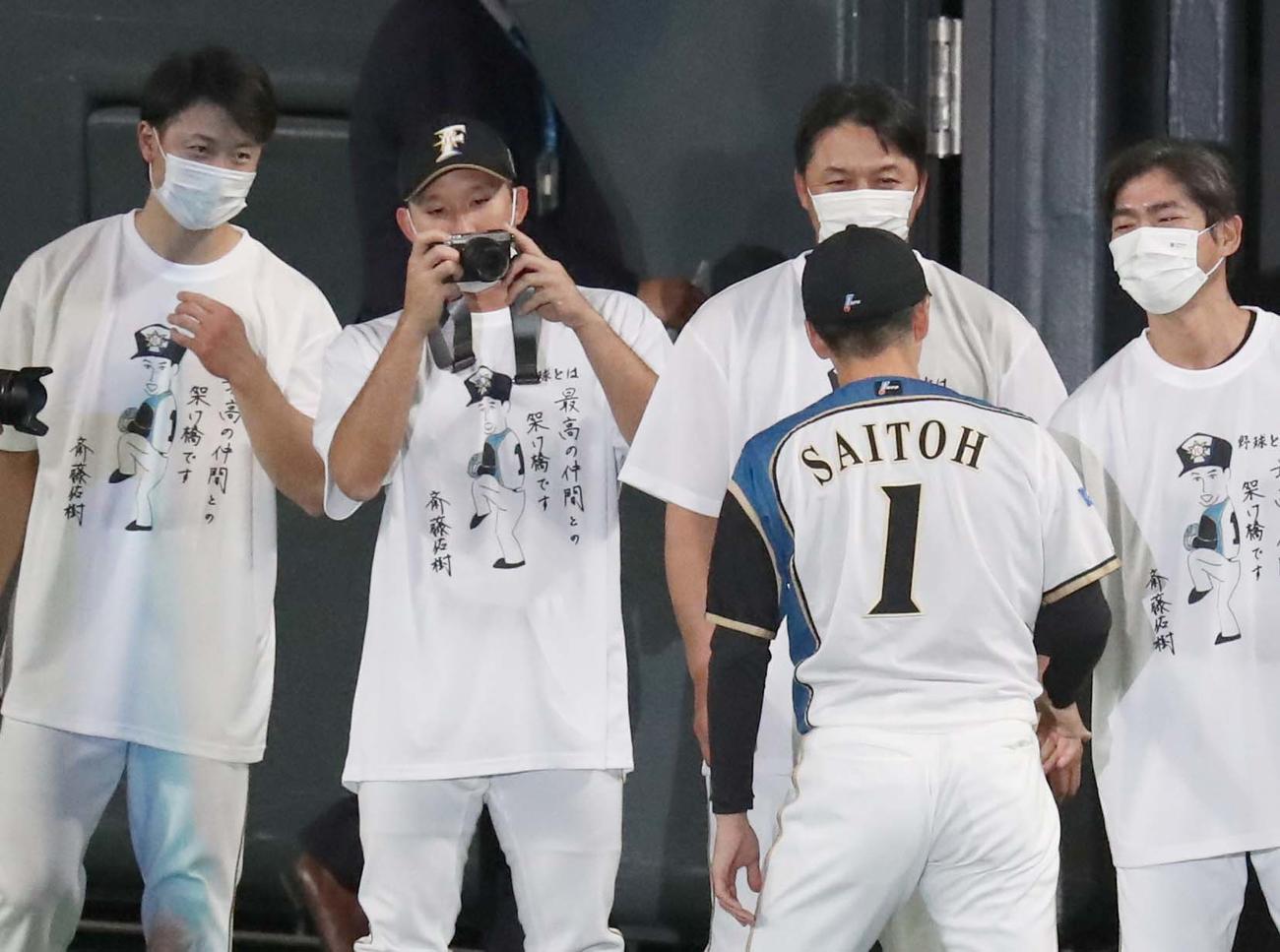 引退セレモニーで斎藤（手前）の写真を撮る杉谷（左から2人目）（撮影・黒川智章）