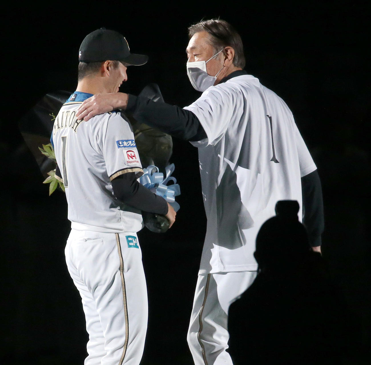 日本ハム対オリックス　引退セレモニーで日本ハム斎藤（左）は荒木投手コーチから花束を受け取る（撮影・佐藤翔太）