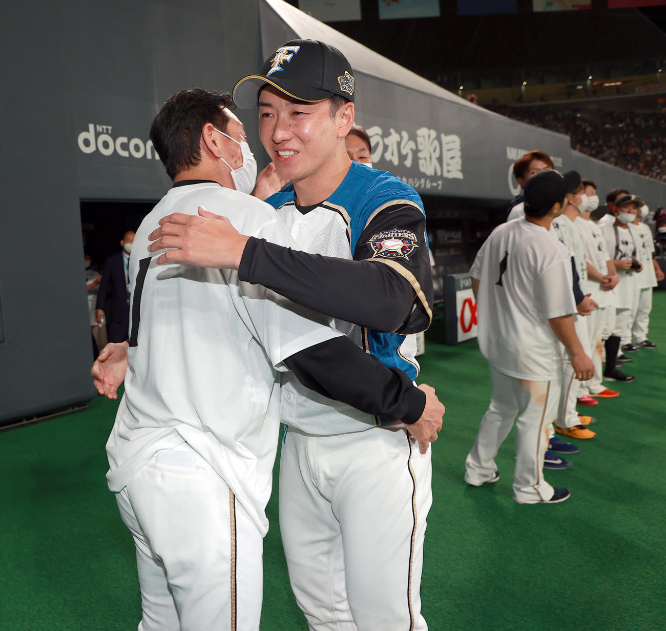 引退セレモニーで日本ハム栗山監督（左）と抱き合う斎藤（球団提供）