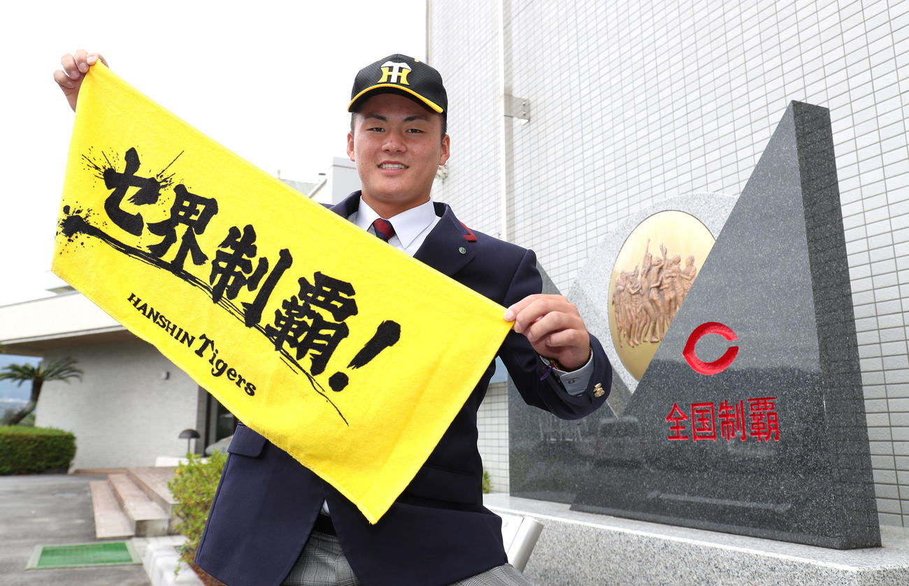阪神から指名あいさつを終えて、セ界制覇！のタオルを広げる智弁学園・前川（撮影・白石智彦）