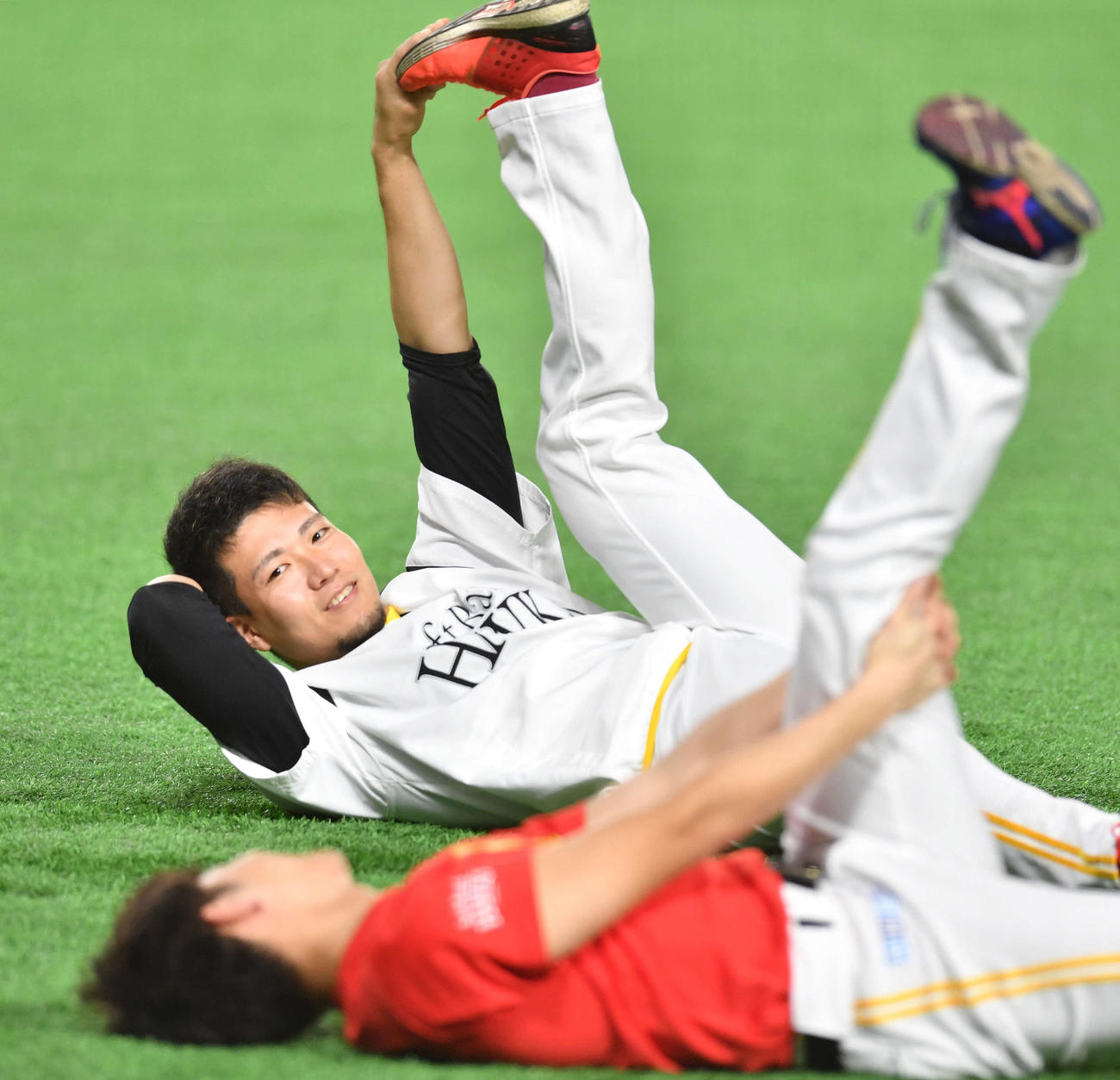 笠谷（手前）と談笑しながらストレッチを行う千賀（撮影・岩下翔太）