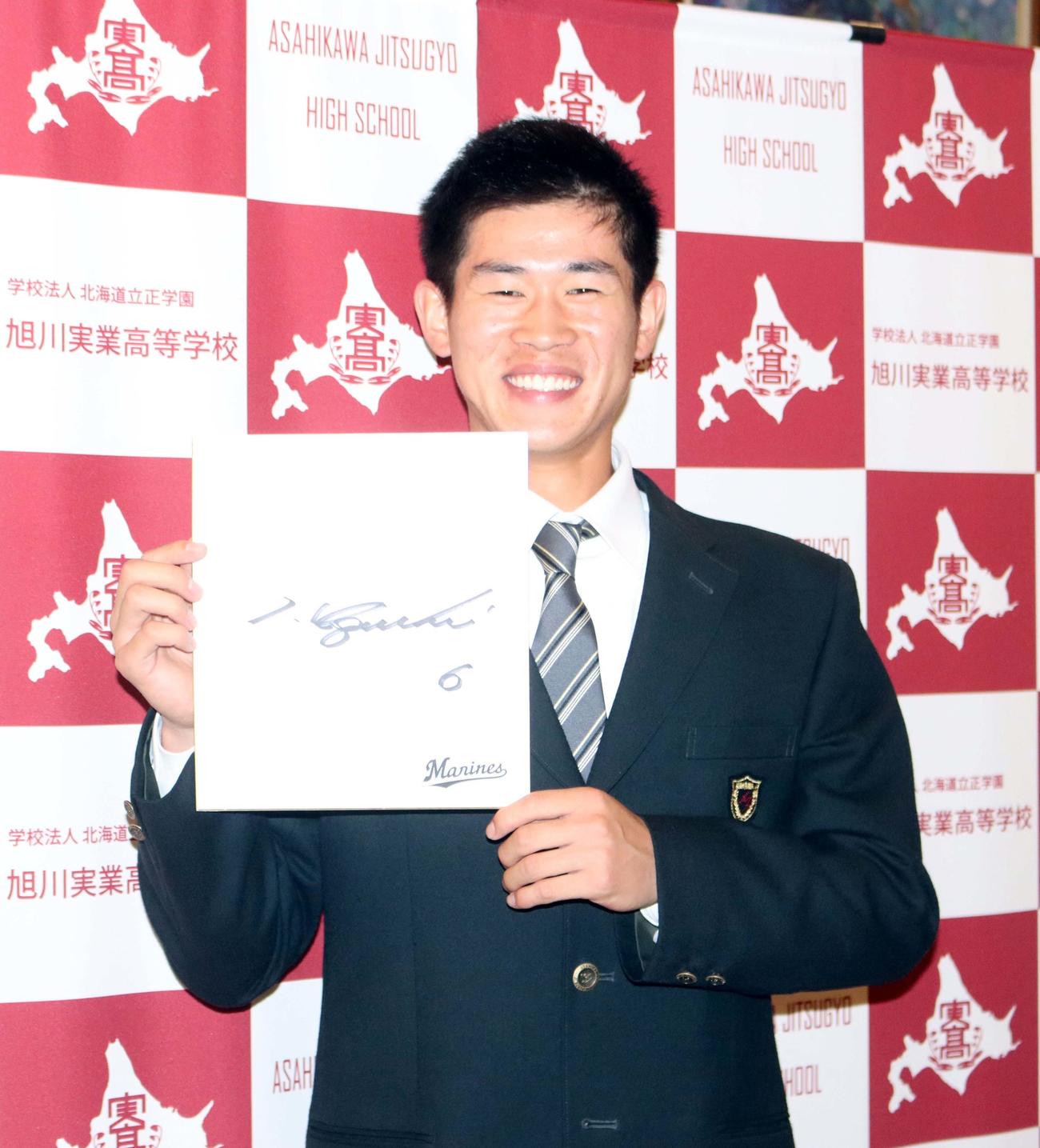ロッテ井口監督のサインを手に笑顔の旭川実・田中（撮影・永野高輔）