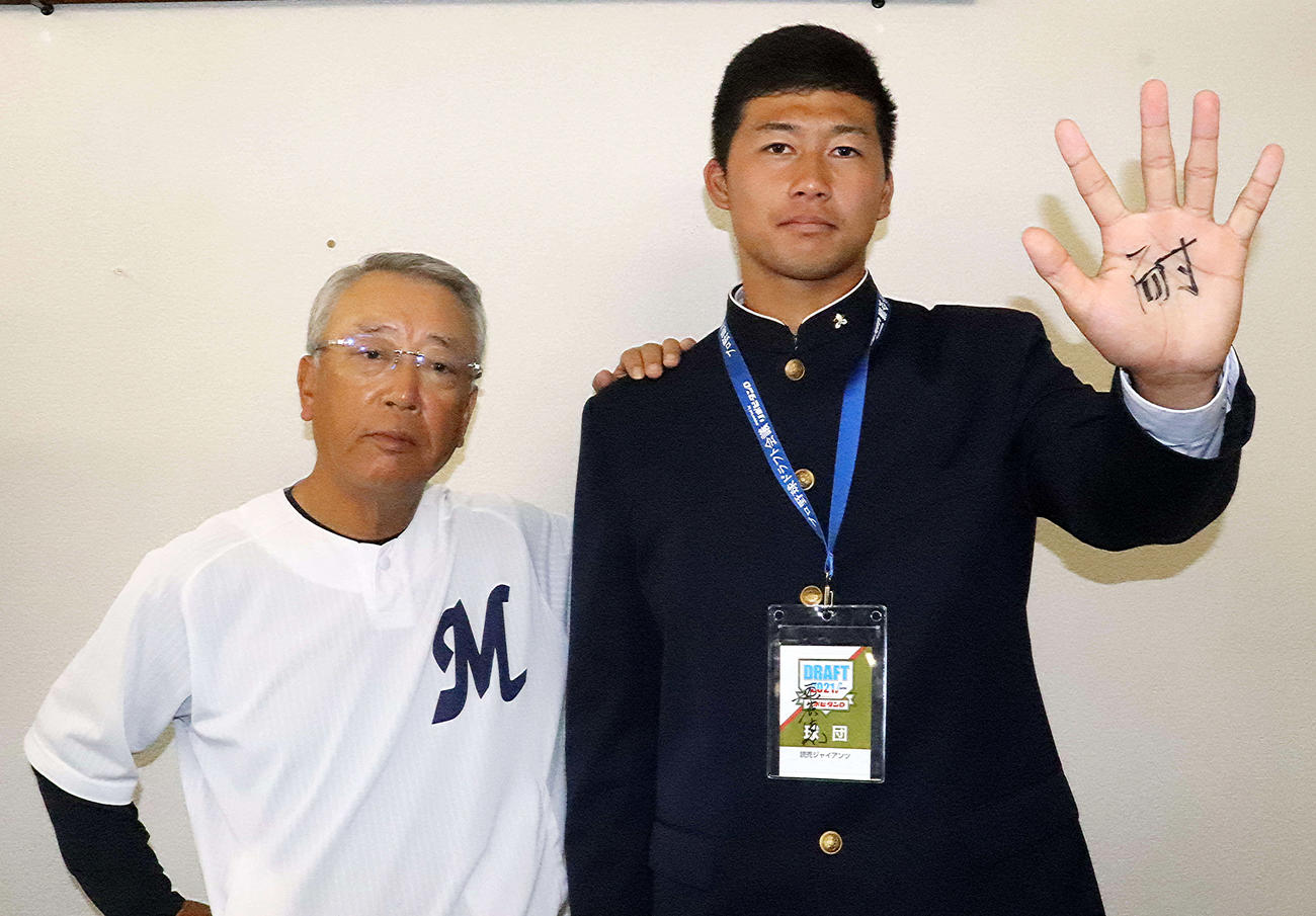 指名あいさつを受けた巨人ドラフト6位の明徳義塾・代木（右）の左手には馬淵監督の書いた「耐」の文字（撮影・小早川宗一郎）