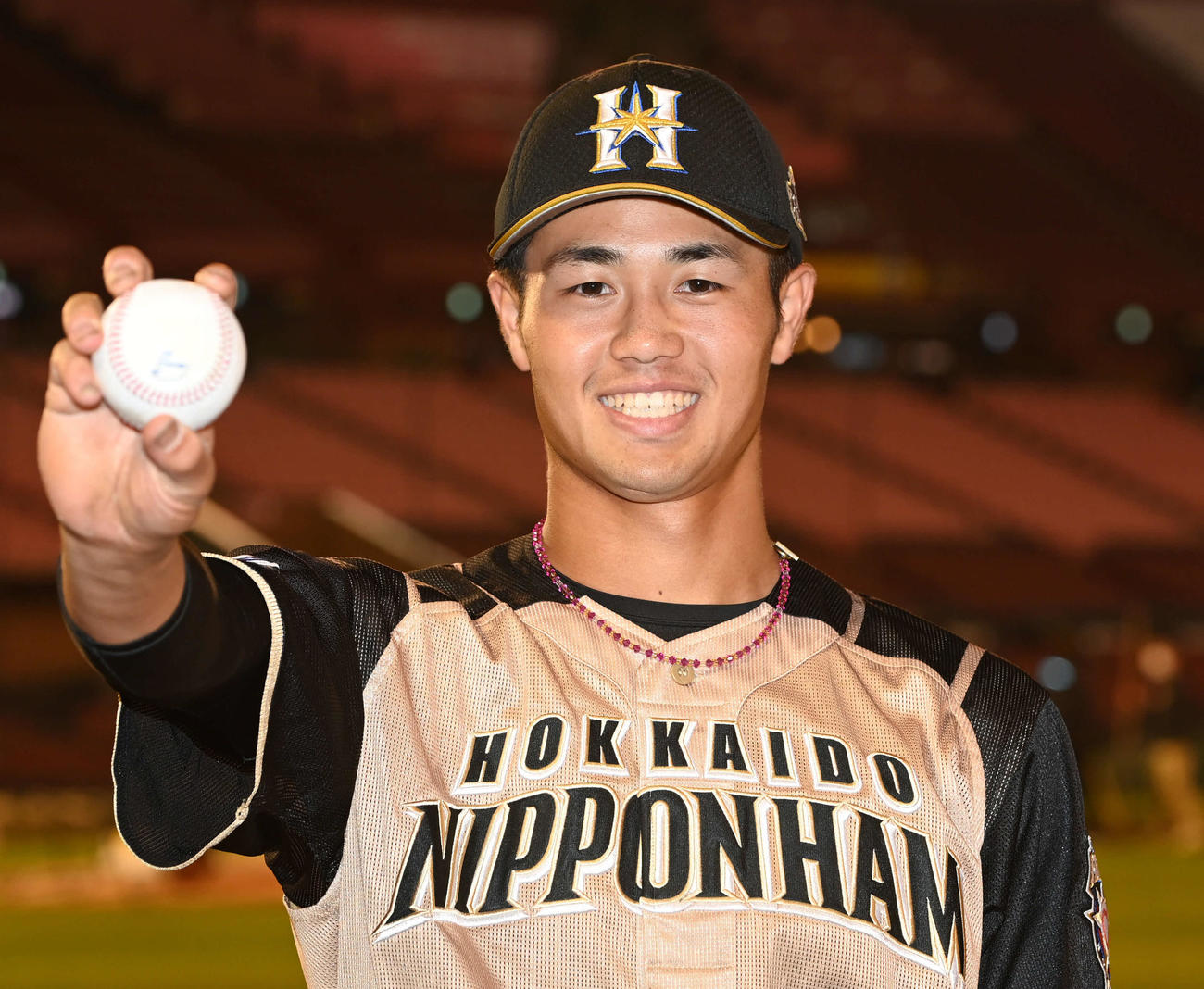 楽天対日本ハム　プロ初安打を放った日本ハム細川は記念球を手に笑顔（撮影・山崎安昭）