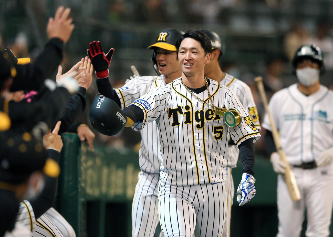 阪神対ヤクルト　1回裏阪神無死一、二塁、近本（手前）は先制の3点本塁打を放ちナインと笑顔でタッチ（撮影・上山淳一）