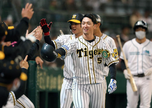 阪神対ヤクルト　1回裏阪神無死一、二塁、近本（手前）は先制の3点本塁打を放ちナインと笑顔でタッチ（撮影・上山淳一）