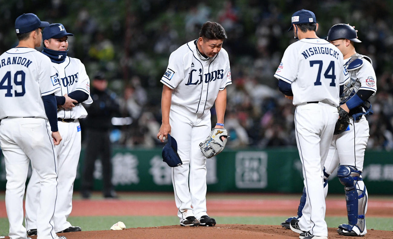 西武対日本ハム　先頭打者の日本ハム近藤に四球を許した西武松坂（中央）は交代を告げにマウンドへ向かう西口投手コーチ（右から2人目）に一礼する（撮影・滝沢徹郎）
