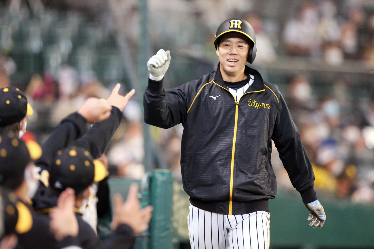 阪神対ヤクルト　5回裏阪神2死二塁、青柳（右）は島田の中前適時打で生還し、ナインの祝福に笑顔を見せる（撮影・上山淳一）