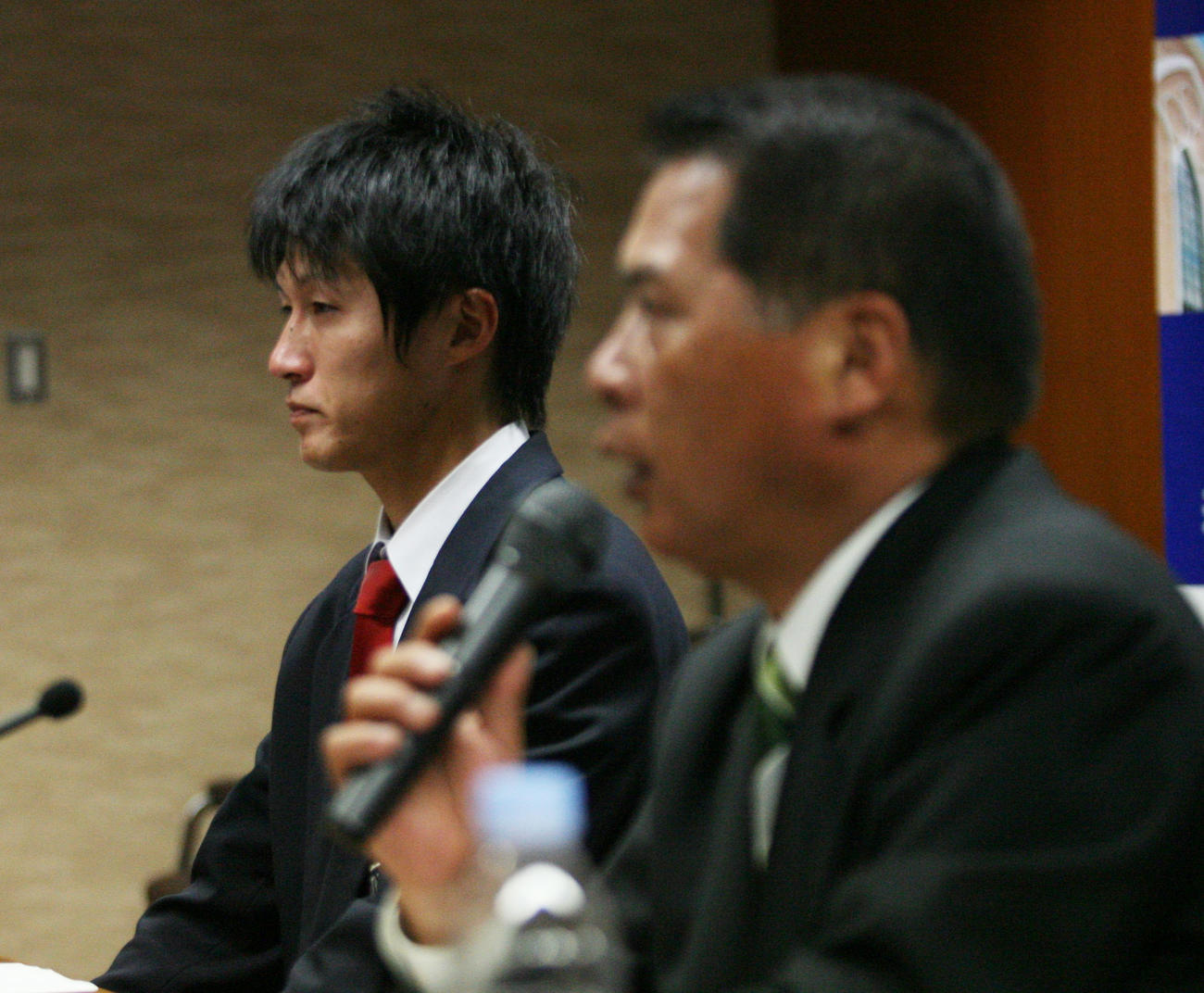 09年10月、ドラフト会議で阪神から5順目の指名を受けた藤川俊介（左）の横でインタビューに応じる榎本保監督