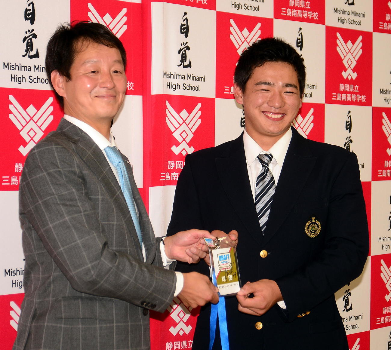 部坂スカウト（左）を通じて石井監督からのサイン入りドラフト会議入館パスを受け取り、笑顔を見せる三島南・前田