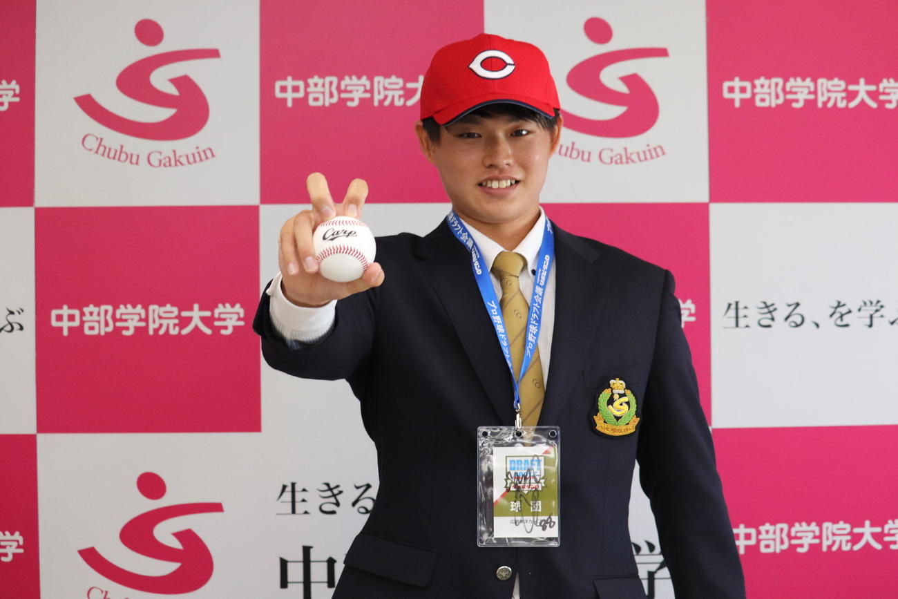ナックルの握りでポーズを取る広島育成4位の坂田（撮影・前原淳）