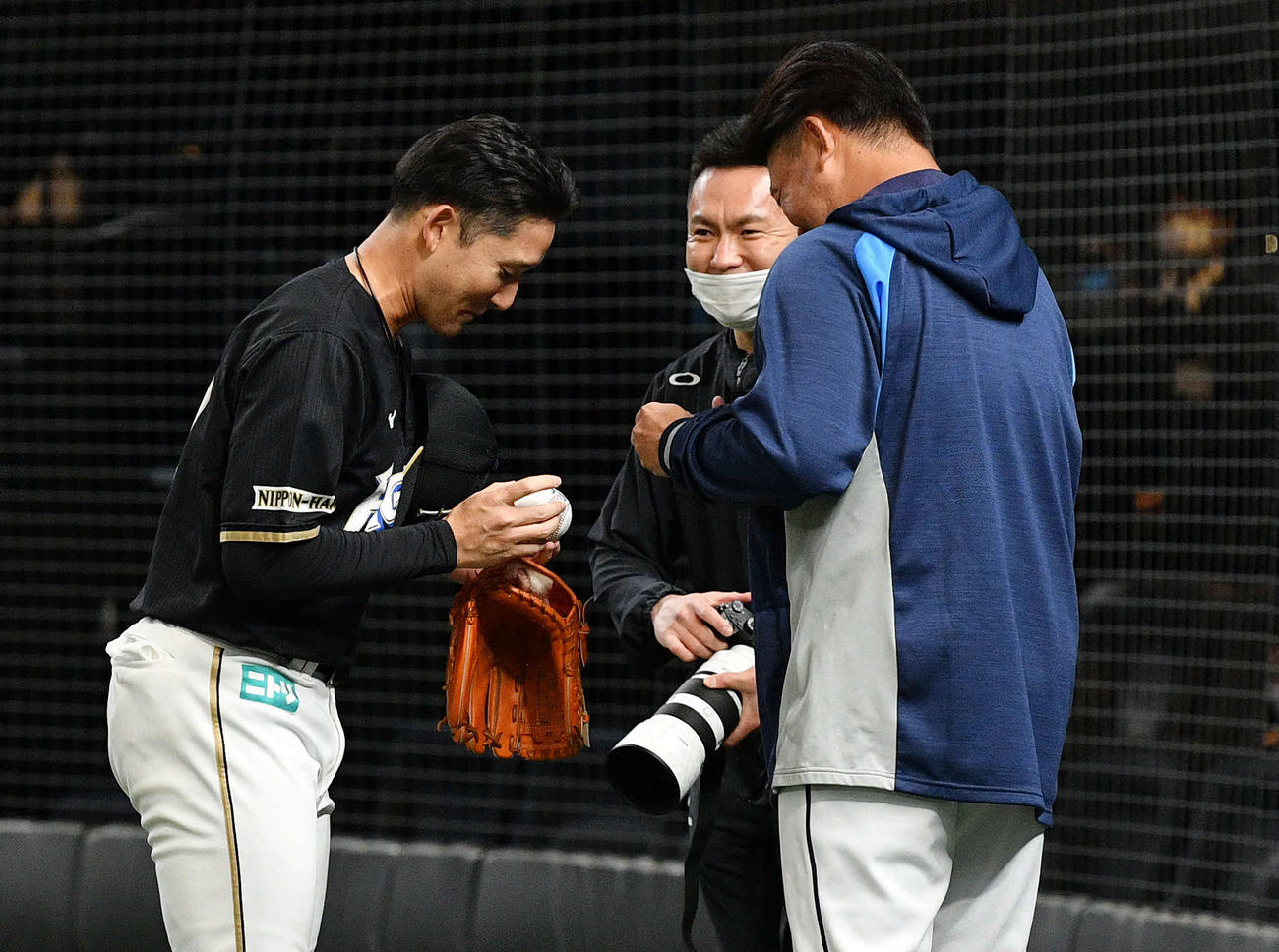日本ハム戦の試合前練習で日本ハム杉谷（左）のボールにサインする西武松坂（右）（撮影・滝沢徹郎）