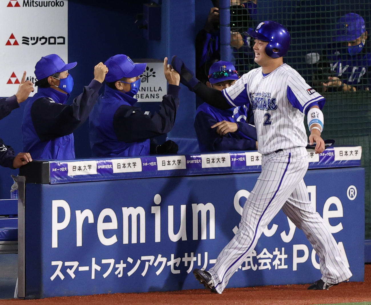 DeNA対巨人　1回裏DeNA2死一塁、宮崎の適時二塁打で生還し、三浦監督（中央）とタッチを交わす牧（撮影・狩俣裕三）