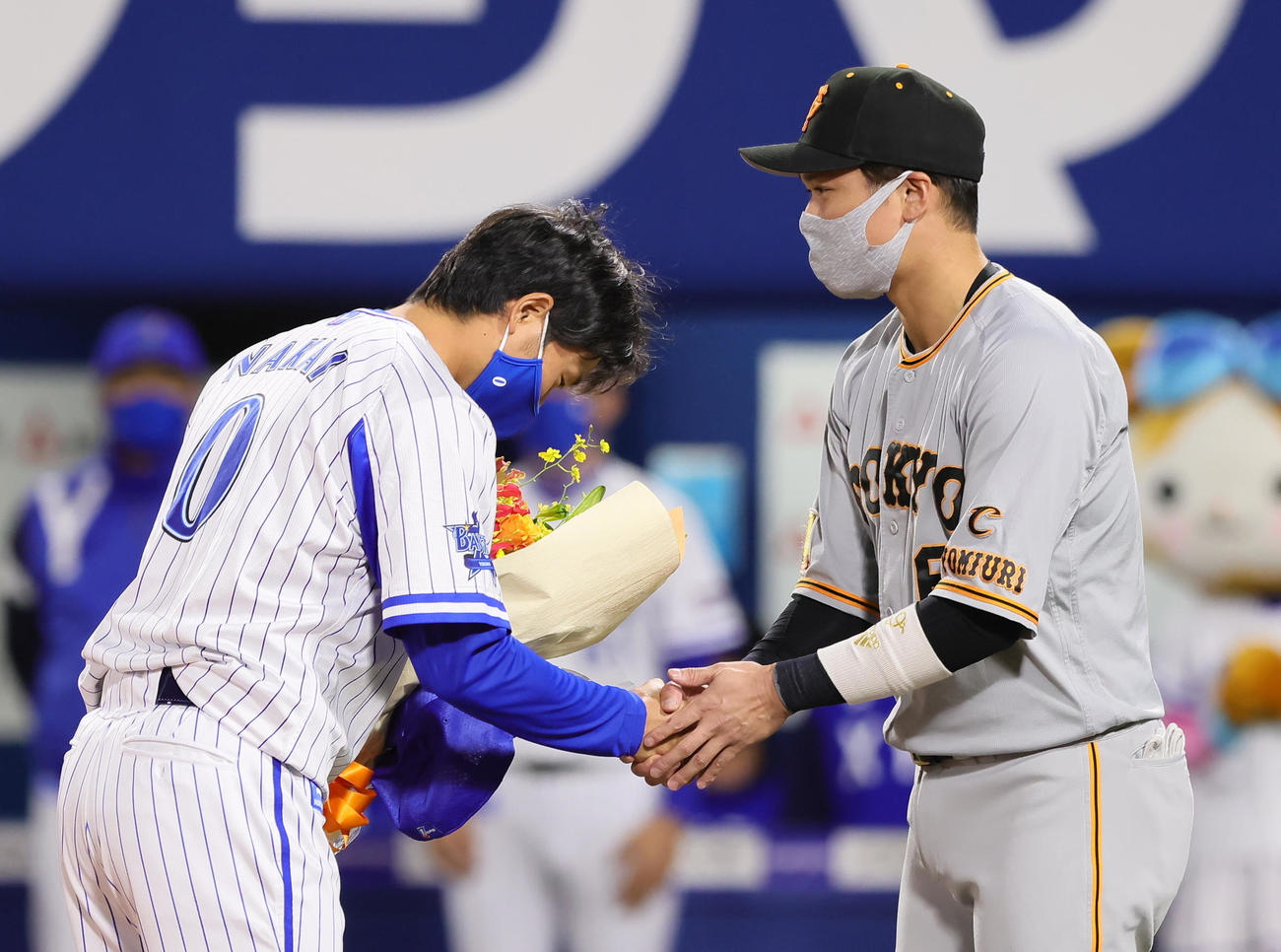 試合前、今季で現役引退するDeNA中井（左）は巨人坂本から花束を贈られ握手を交わす（撮影・足立雅史）