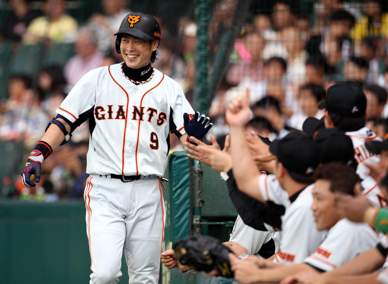 09年8月1日、阪神対巨人　ランニング本塁打を放った亀井義行は笑顔でナインとタッチ