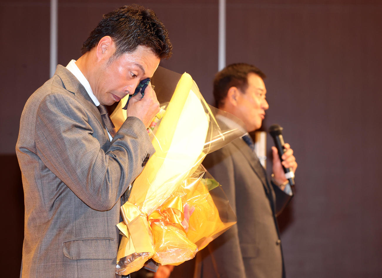 引退会見の最後にサプライズで登場した原監督（右）の送る言葉に、汗をぬぐい神妙な表情を見せる亀井（撮影・狩俣裕三）
