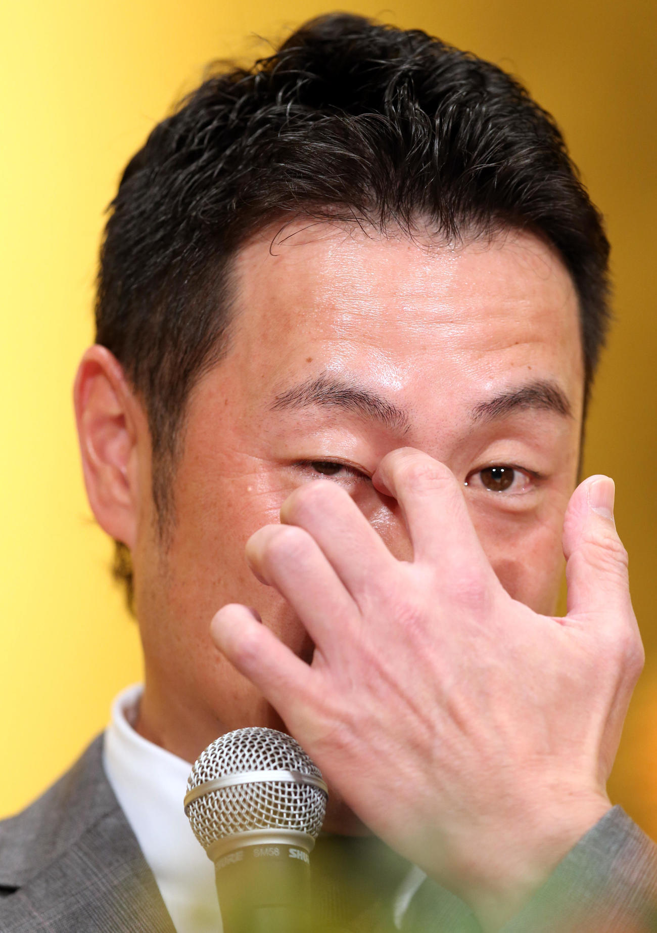 引退会見で時折、目に手をやる亀井（撮影・狩俣裕三）