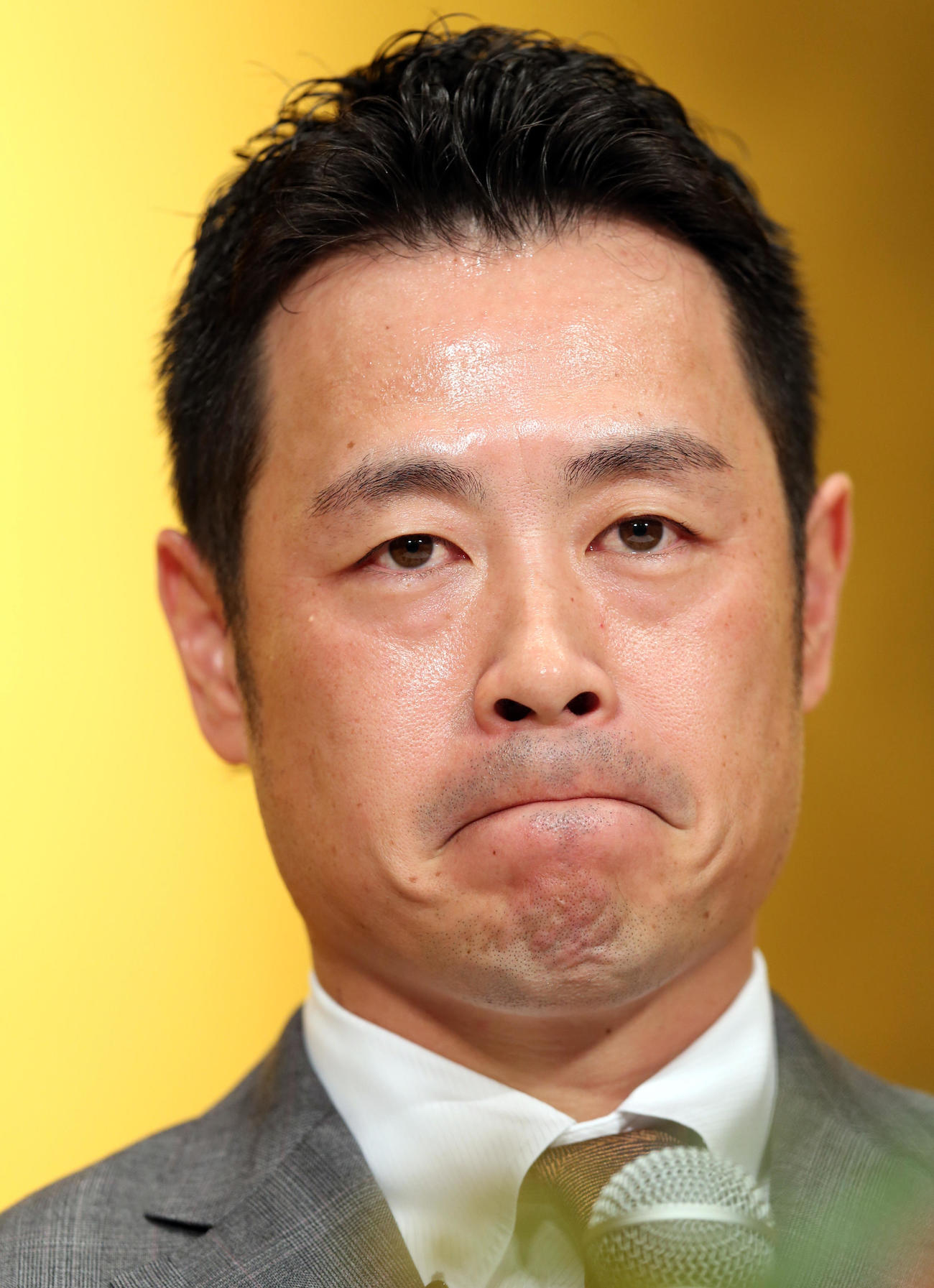 引退会見で時折、口を真一文字にし、神妙な表情を見せる亀井（撮影・狩俣裕三）