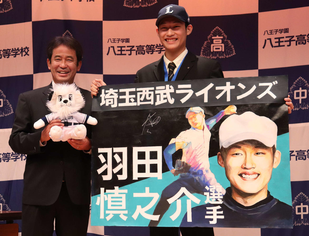 指名あいさつにて、笑顔で似顔絵を持つ八王子学園八王子・羽田慎之介投手（右）と西武・潮崎哲也編成ディレクター（撮影・阿部泰斉）