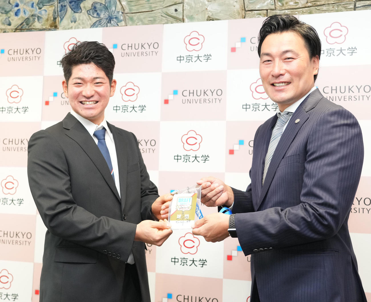 阪神筒井スカウト（右）から矢野監督のサイン入りドラフト会議パスを受け取る中京大学・伊藤稜（撮影・森本幸一）