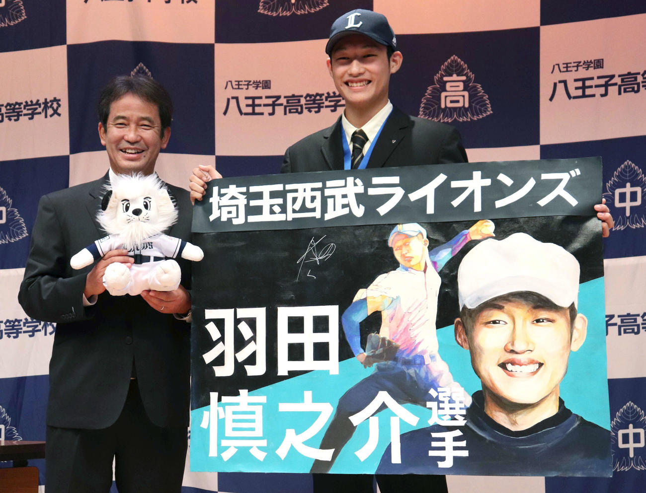 指名あいさつを終え、笑顔で似顔絵を持つ八王子学園八王子・羽田（右）と西武潮崎編成ディレクター（撮影・阿部泰斉）