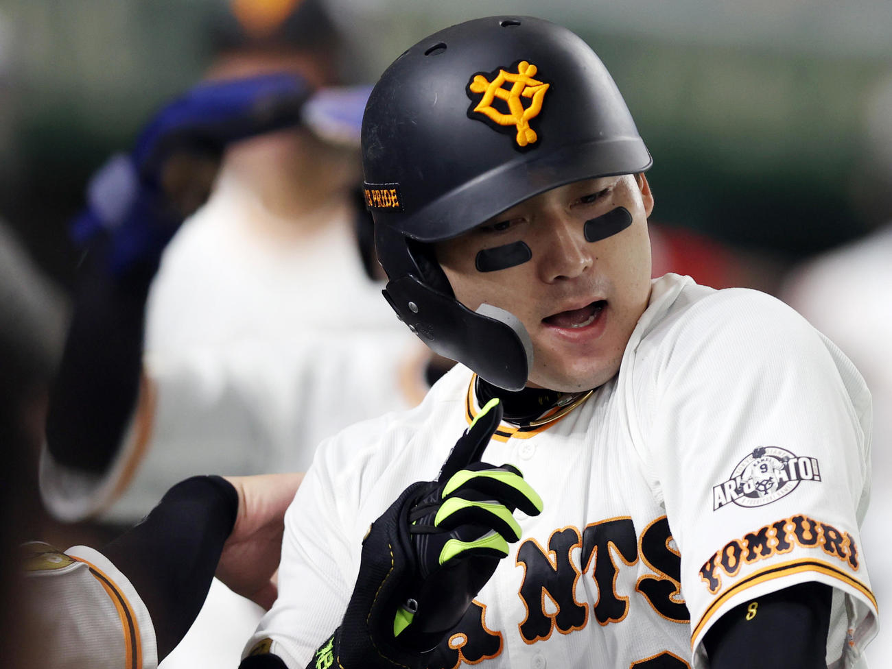 巨人対ヤクルト　1回裏巨人無死一、三塁、先制3点本塁打を放ち、亀井の引退記念ワッペンを指さす丸（撮影・狩俣裕三）