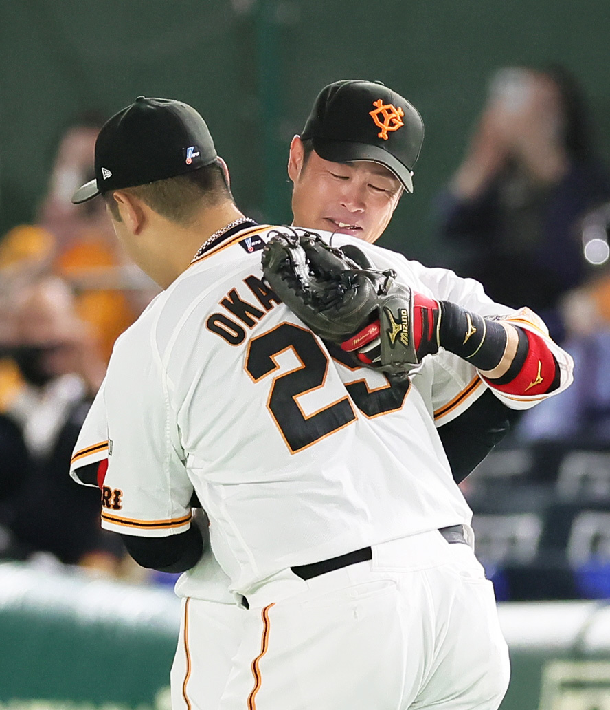 巨人対ヤクルト　6回表、右翼の守備についた亀井（後方）はそのまま交代となり、岡本和と抱き合う（撮影・足立雅史）