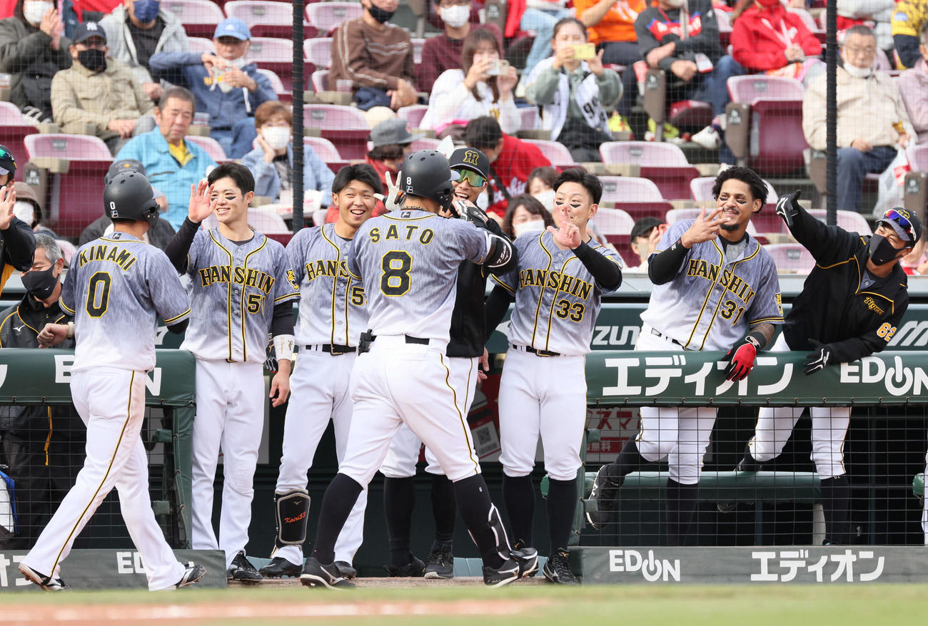 広島対阪神　2回表阪神1死一、三塁、先制右越え3点本塁打を放った佐藤輝を迎えるナイン（撮影・加藤孝規）