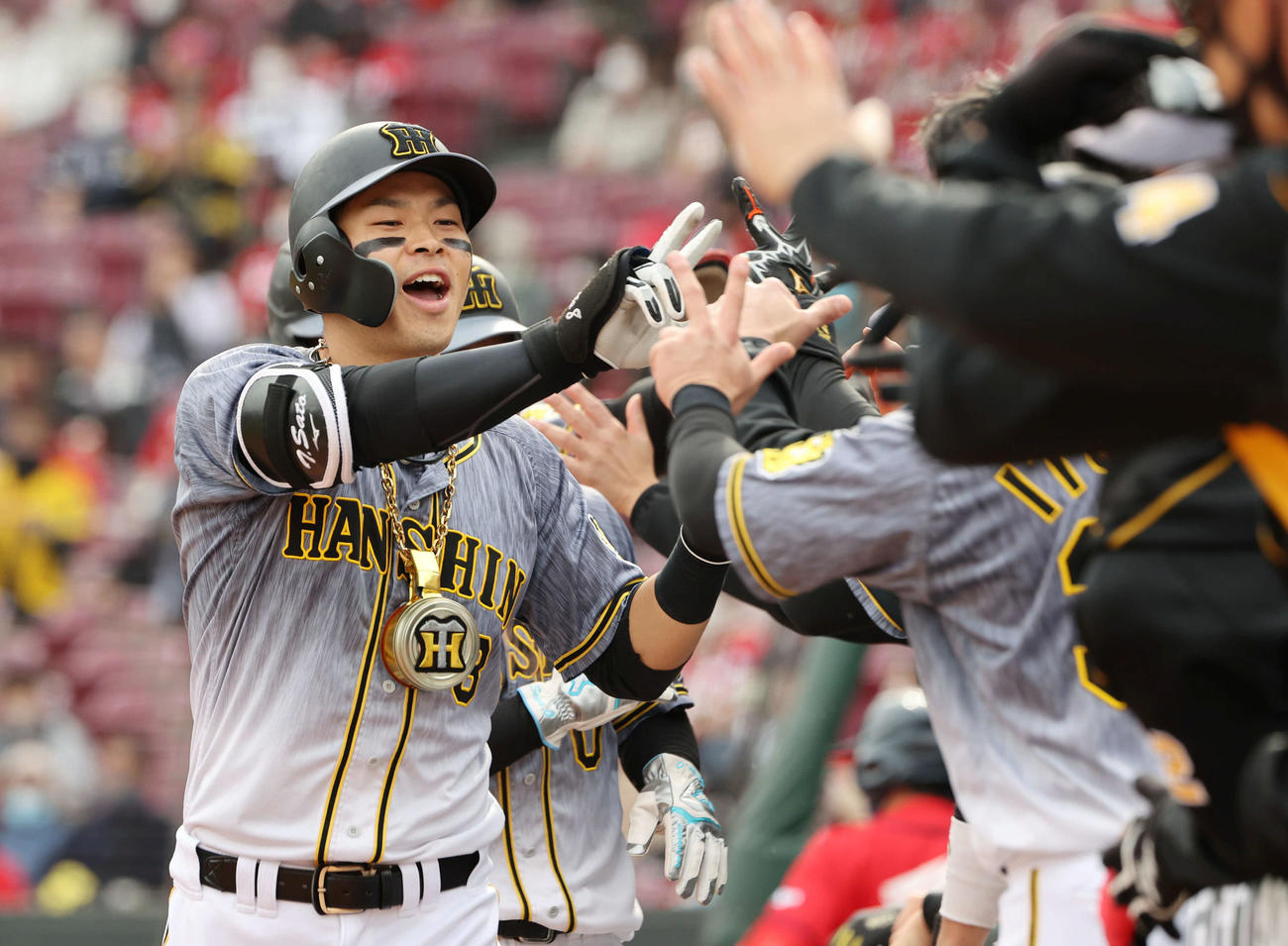 広島対阪神　2回表阪神1死一、三塁、先制右越え3点本塁打を放った佐藤輝はナインに迎えられる（撮影・朝日新聞上田潤）